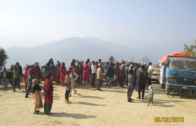 공터에 모인 타쿠르 마을 주민들. 건너 편에 산맥이 보이는 것처럼 타쿠르는 높은 고도에 위치한 산간마을.